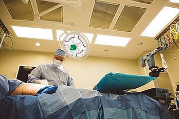 Surgeon operating in an operating room.