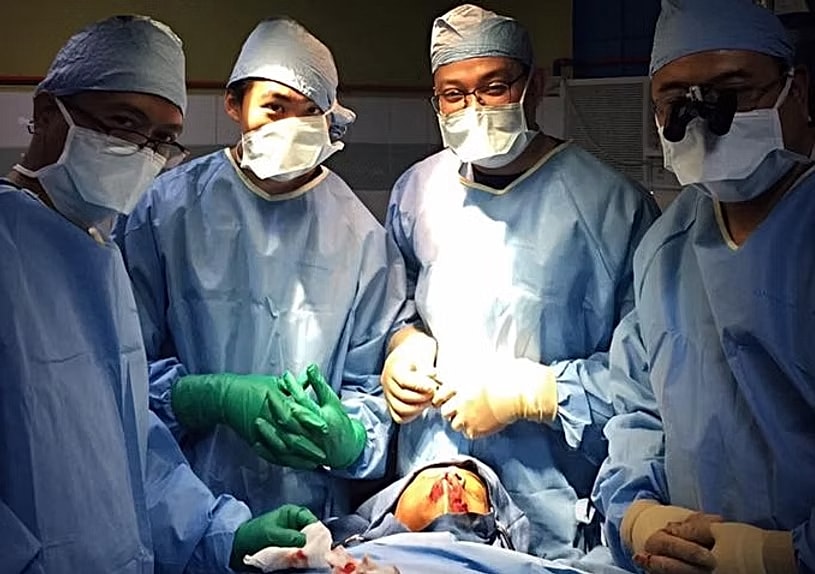 Surgeons performing a medical procedure in operating room.
