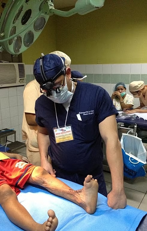 Surgeon attending to a patient's leg injury.