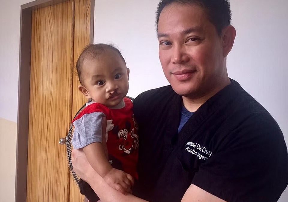 Doctor holding baby in a medical setting.