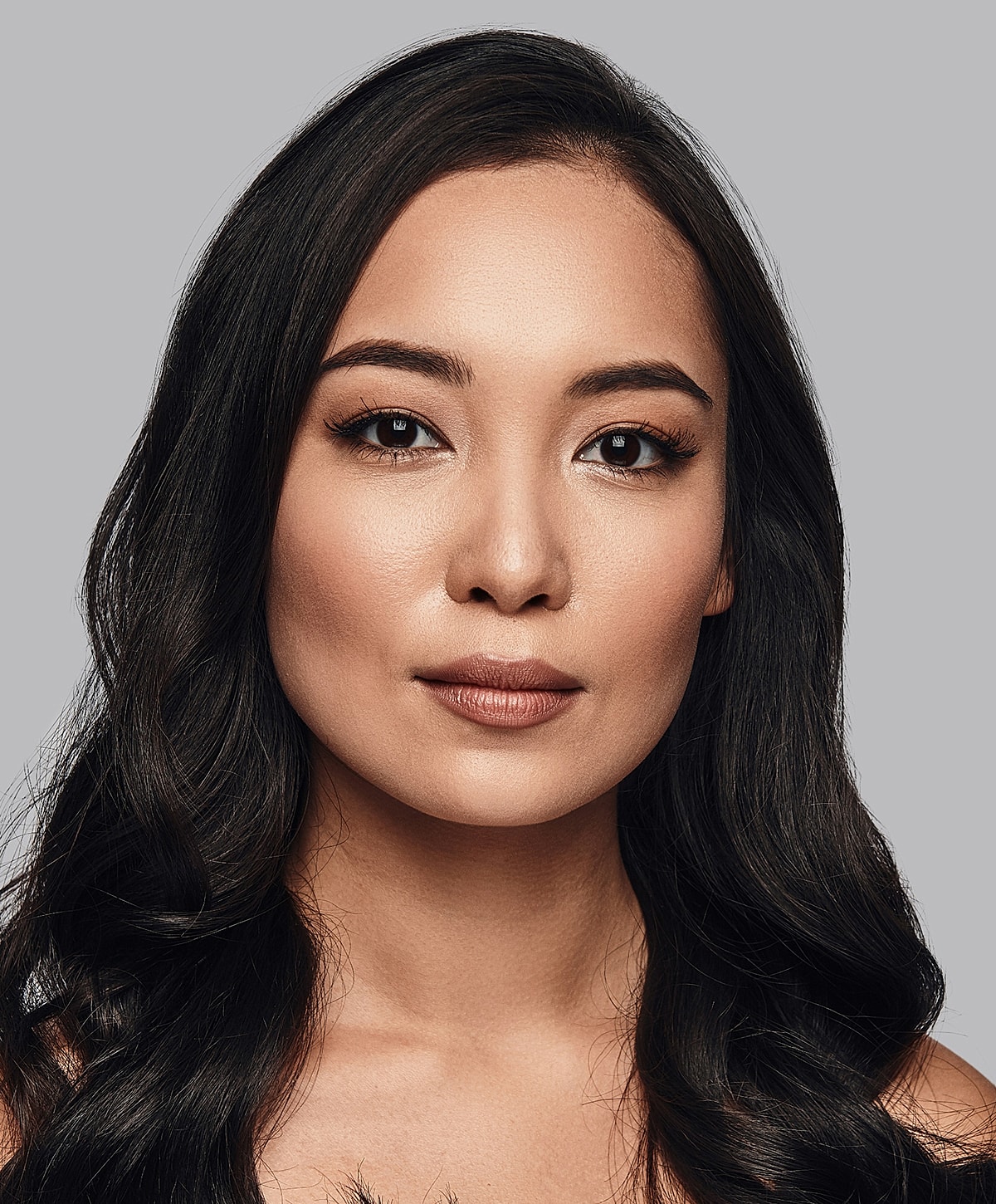 Portrait of a woman with black hair and makeup.