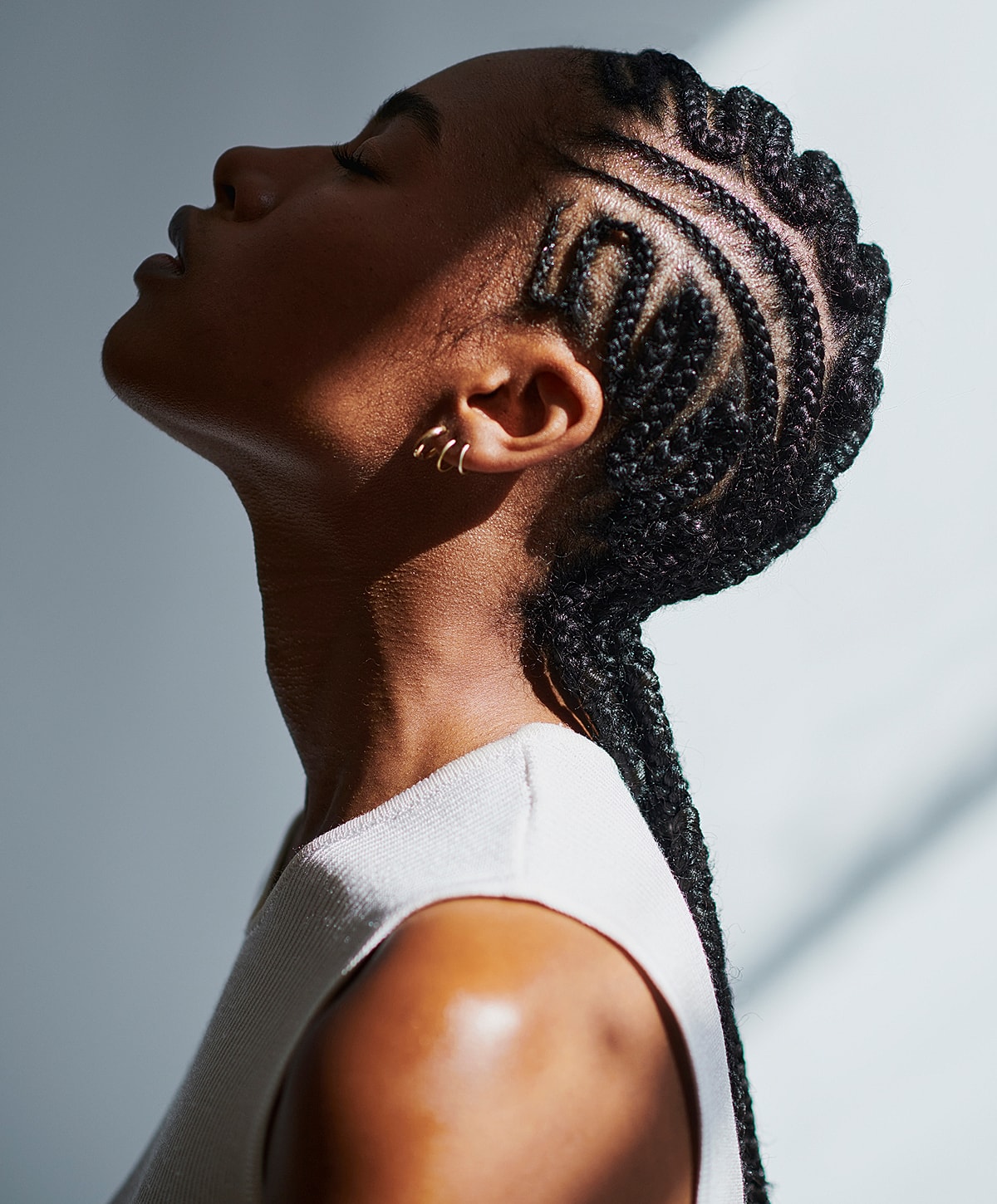 Woman with braided hairstyle in profile view.