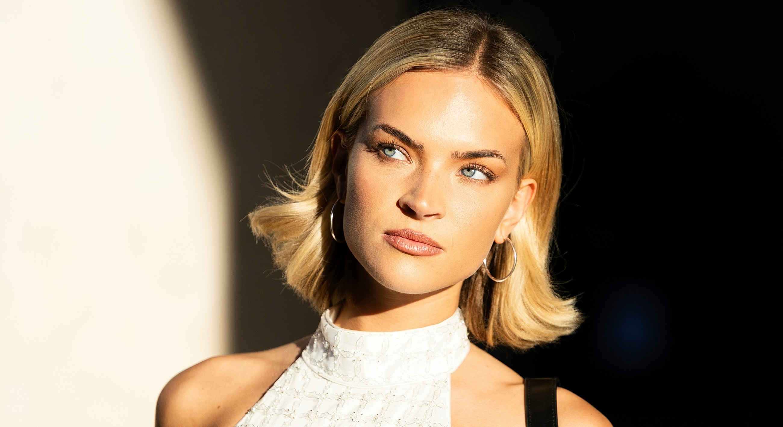 Person looking thoughtfully, wearing a stylish outfit.