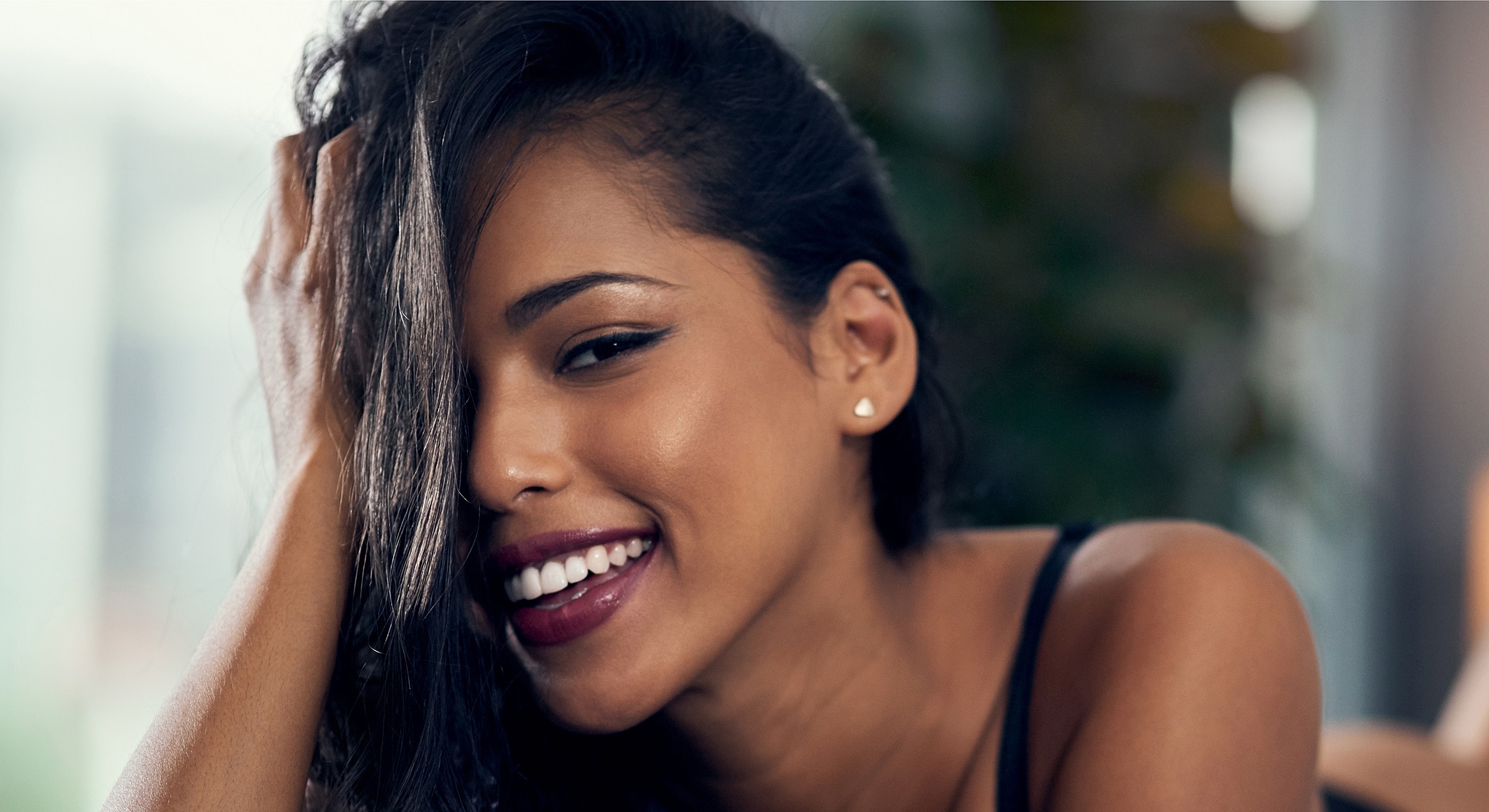 Smiling woman with long hair and earrings.