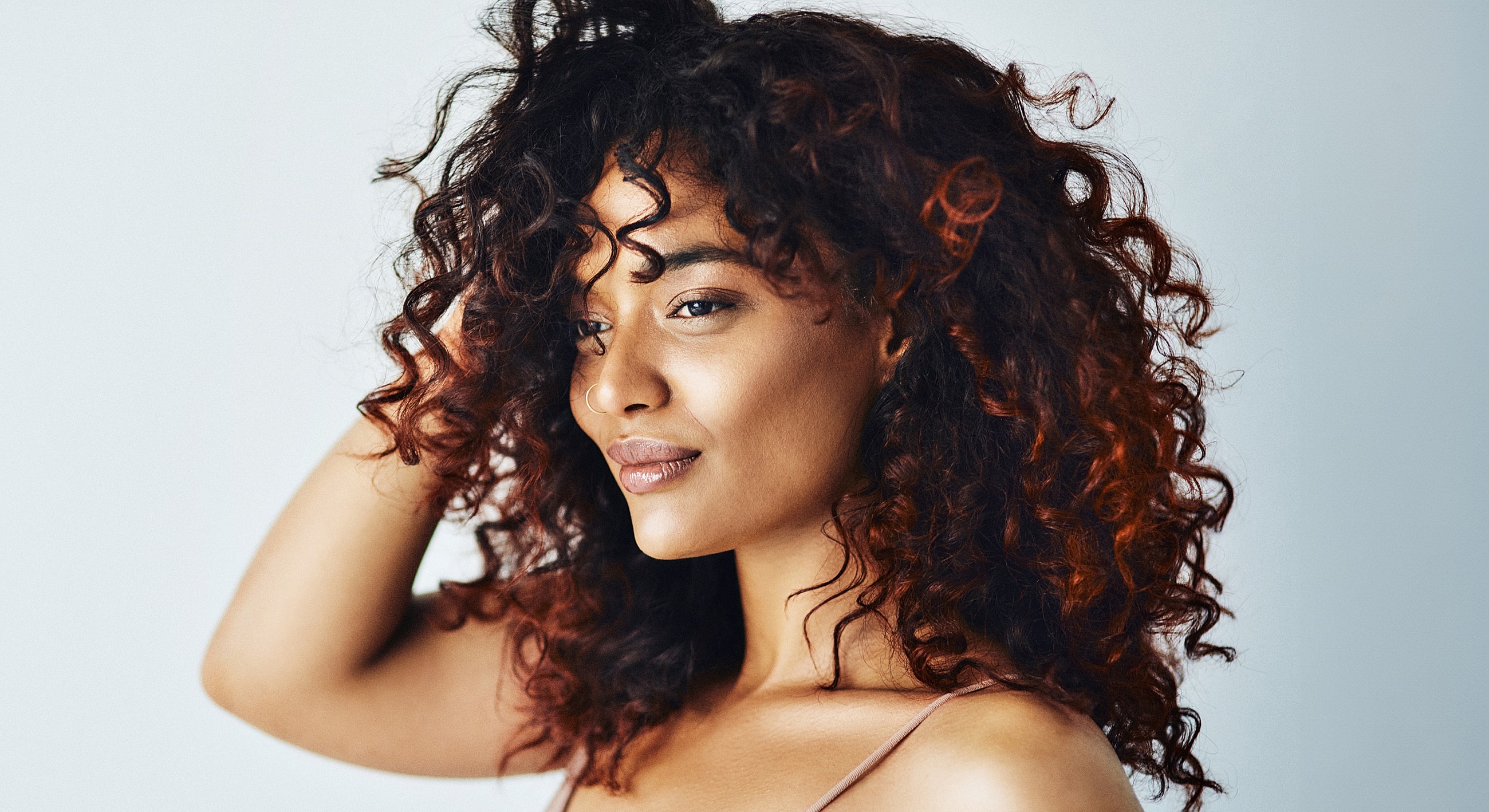 Woman with curly hair against a light background