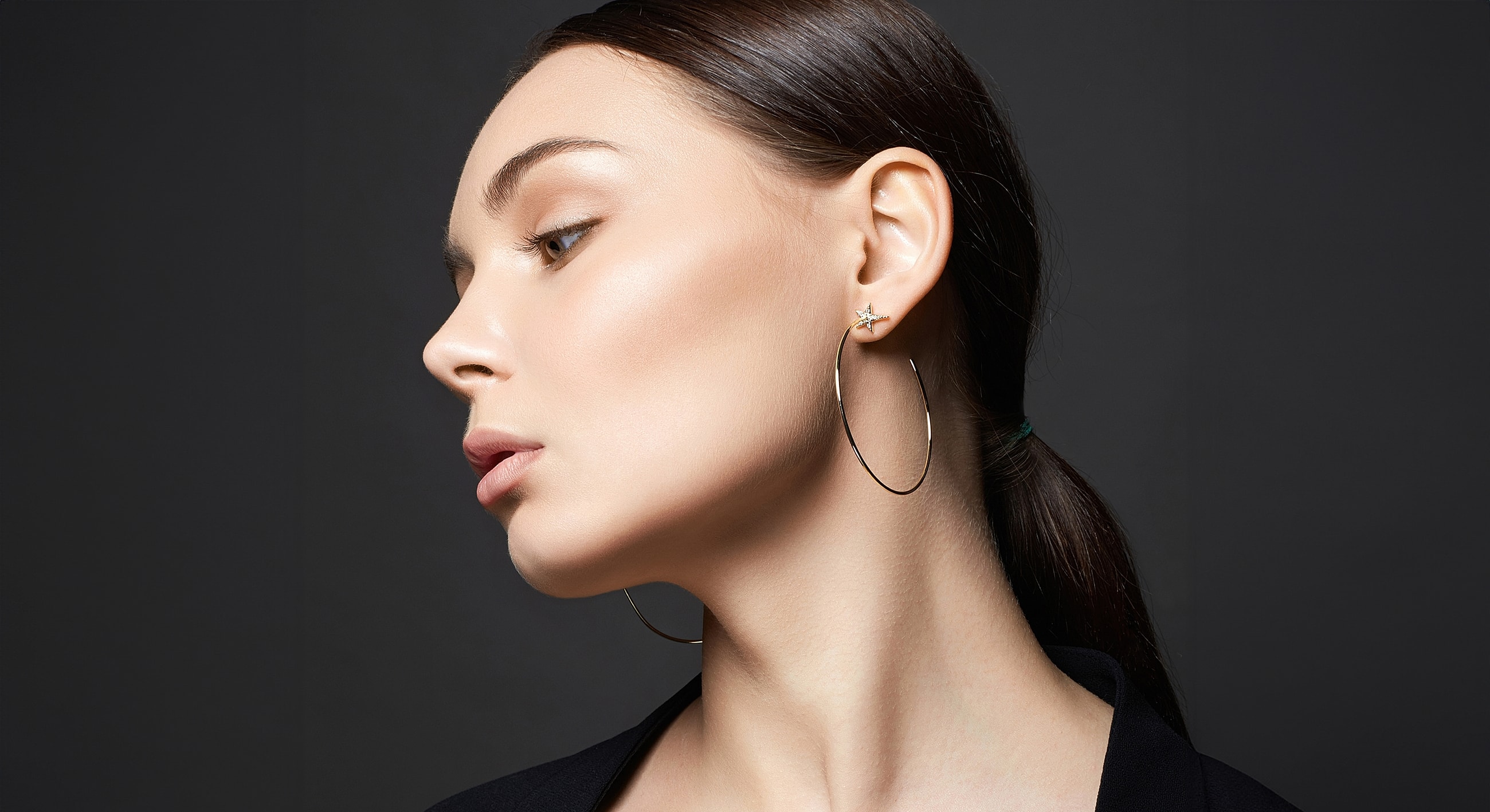 Model showcasing elegant earrings and makeup.